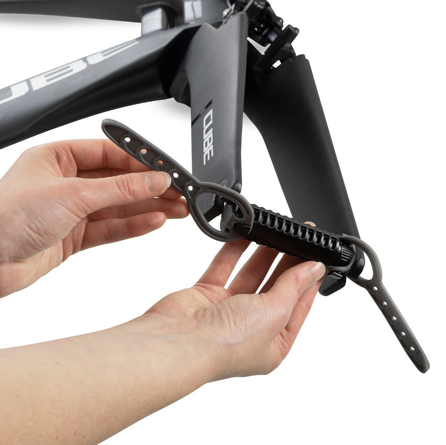 Person adjusting a black bicycle component on a white background