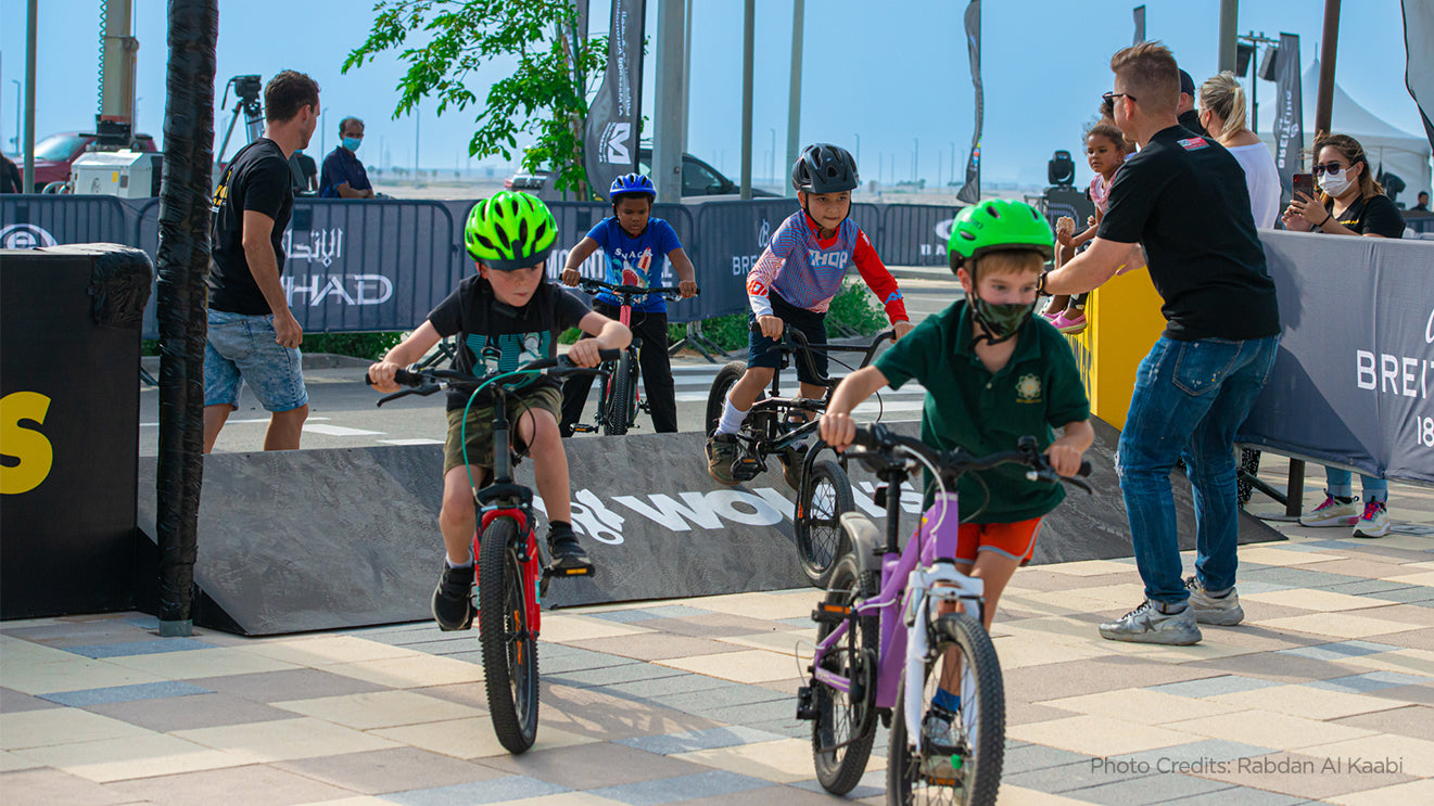 A group of  kids learning how to rid a bike